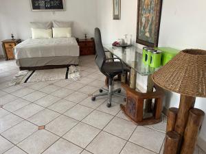 a bedroom with a desk and a bed and a table at Royal View Cottage in Hartbeespoort