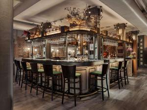 a bar in a restaurant with a bunch of stools at The Porter House Hotel Sydney - MGallery in Sydney