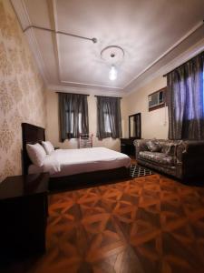 een slaapkamer met een groot bed en een bank bij شقق العنوان للوحدات المخدومة ALanwaan apartments for serviced units in Dammam