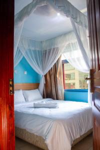 a bedroom with a canopy bed with white curtains at Deka Self Contained Rooms in Nairobi