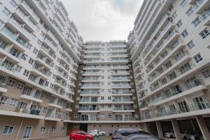 a large apartment building with cars parked in a parking lot at RedLiving Apartemen Gateway Pasteur - TN Hospitality 3 Tower Jade B in Bandung