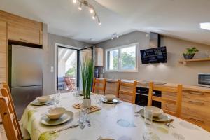 una sala da pranzo con un tavolo e una cucina di La Vougerotte - Terrasse Vue Montagnes a Vougy