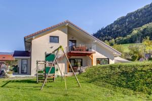 a yard with a playground in front of a house at La Vougerotte - Terrasse Vue Montagnes 