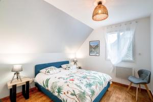 a bedroom with a bed and a blue chair at La Bigourdane in Lau-Balagnas
