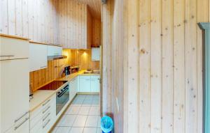 a kitchen with wooden walls and white cabinets and a stove at 2 Bedroom Stunning Home In Rechlin in Rechlin