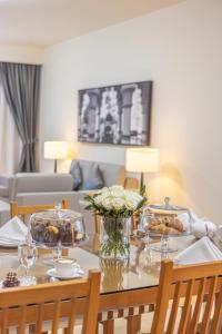 a dining room table with food and flowers on it at Golden Sands Suites in Dubai