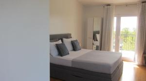 a bedroom with a bed and a balcony at Ogreca in Skradin