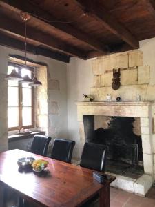 a dining room with a table and a fireplace at Gîte de L’Edelinie in Nanteuil-de-Bourzac