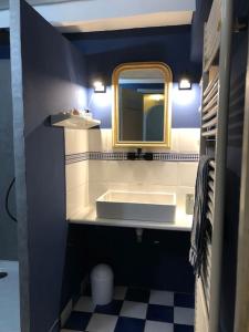 a blue bathroom with a sink and a mirror at Gîte de L’Edelinie in Nanteuil-de-Bourzac