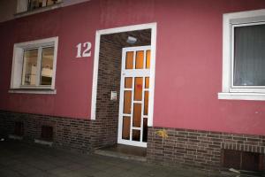 un edificio rojo con una puerta con el número 12 en HannoverCity Appartment, en Hannover