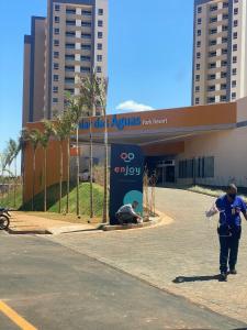 un homme debout devant un bâtiment dans l'établissement Enjoy Solar das Águas Park Resort, à Olímpia