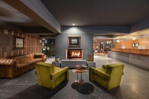 a lobby with two green chairs and a fireplace at Eurostars Santa Luzia in Guimarães