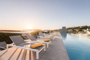 a row of lounge chairs next to a swimming pool at Eurostars Santa Luzia in Guimarães