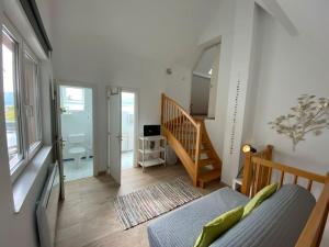 um quarto com uma escada e um quarto com um sofá em Logement de charme au coeur de la nature em Osenbach