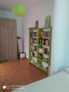 una habitación con una estantería verde con libros en Agradable casa rural con chimenea y buenas vistas, en Cañaveral de León