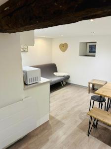 uma sala de estar com uma cama e uma mesa em Gite le 16 em Ribeauvillé