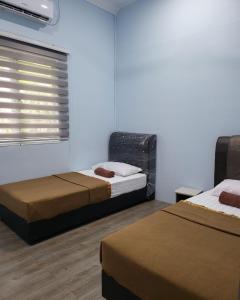 a room with two beds and a window at IBAI COTTAGE KUALA TERENGGANU (HOMESTAY) in Kuala Terengganu