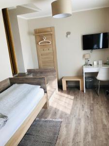 a bedroom with a bed and a desk and a tv at Hotel Altstadt Wöllbacher Tor in Wetzlar