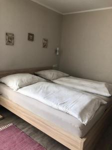 um quarto com 2 camas com lençóis brancos e almofadas em Hotel Altstadt Wöllbacher Tor em Wetzlar