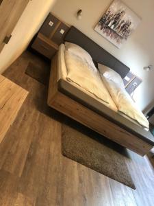 a bed in a bedroom with a wooden floor at Hotel Altstadt Wöllbacher Tor in Wetzlar