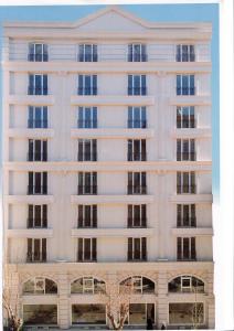 a tall white building with windows at Feyzan Hotel in Corum