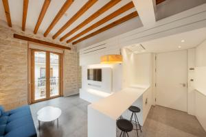 eine Küche und ein Wohnzimmer mit einem blauen Sofa in der Unterkunft Tandem Pórtico Alicante Suites in Alicante