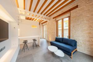 Tandem Pórtico Alicante Suites في أليكانتي: غرفة معيشة مع أريكة زرقاء وطاولة