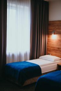 een slaapkamer met 2 bedden en een raam bij S7 Hotel in Kielce