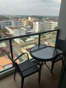 - Balcón con mesa y sillas y vistas a la ciudad en Walking Street Condo Beautiful 1 king bedroom, en Ángeles