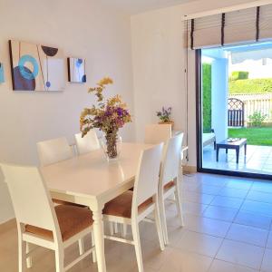 a dining room with a white table and chairs at Mi casita playera in El Rompido