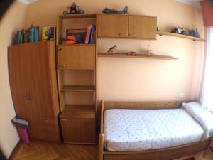 Dormitorio pequeño con cama y armarios de madera en Apartment - 2 Bedrooms - 0137, en Cangas de Morrazo