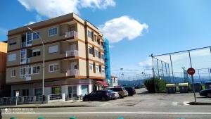 un edificio alto con coches estacionados en un estacionamiento en Apartment - 2 Bedrooms - 0137, en Cangas de Morrazo