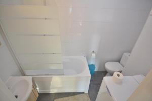a white bathroom with a toilet and a sink at Wczasowa 3 in Warsaw +17 photos