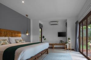 a bedroom with a large bed and a tv at Baan Khao Hua Jook in Chaweng