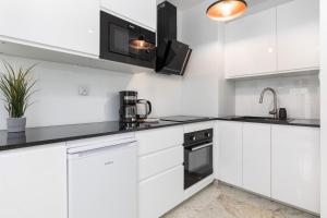 Kuchyňa alebo kuchynka v ubytovaní Kapitański Mostek Apartments Kołobrzeg by Noclegi Renters + 35 fotografií