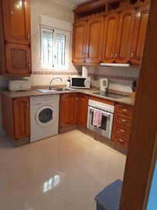 a kitchen with wooden cabinets and a washing machine at Lovely 2-Bed Apartment in Orihuela Costa