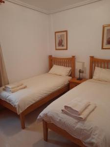 a room with two beds with towels on them at Lovely 2-Bed Apartment in Orihuela Costa