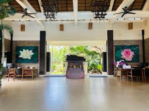 a lobby with a fireplace and tables and chairs at THE BLOSSOM RESORT ISLAND - All Inclusive in Da Nang
