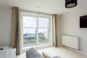 a living room with a large window and a couch at Stunning 2 bed apartment, fabulous sea view & 2 minutes to beach with parking in Southbourne