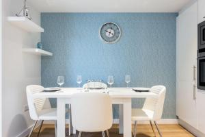 a dining room with a white table and chairs at Stunning 2 bed apartment, fabulous sea view & 2 minutes to beach with parking in Southbourne