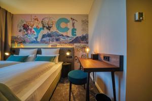 een hotelkamer met een bed en een bureau bij NYCE Hotel Ulm in Ulm