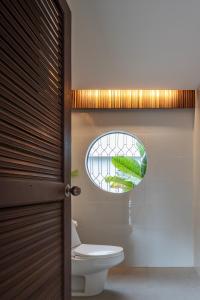 La salle de bains est pourvue de toilettes et d'une fenêtre. dans l'établissement Baan Khao Hua Jook, à Chaweng