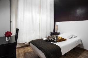 a bedroom with a bed with a black and white headboard at THC Gran Via Hostel in Madrid