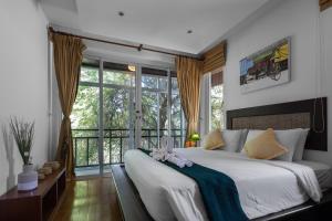a bedroom with a large bed and a large window at Baan Khao Hua Jook in Chaweng
