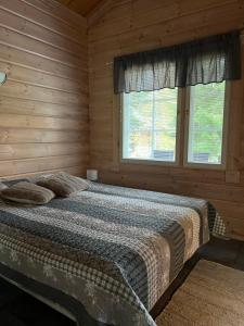 a bedroom with a bed in a wooden cabin at Holiday Home Amero purnu 4 in Kolinkylä