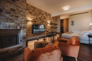 a living room with a large stone wall at Lefkara Luxury Suites in Pano Lefkara