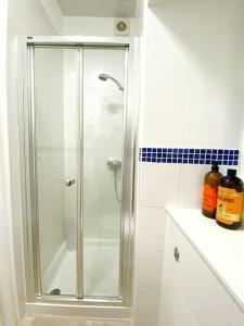 um chuveiro com uma porta de vidro na casa de banho em The Wee Bunk House - Innerleithen em Innerleithen