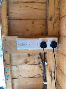eine Wand mit einer elektrischen Box an einer Holzwand in der Unterkunft The Wee Bunk House - Innerleithen in Innerleithen
