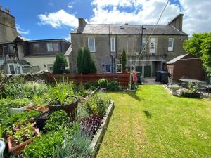 a garden with plants in the yard of a house at The Wee Bunk House - Innerleithen in Innerleithen