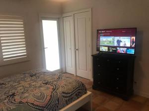 a bedroom with a bed and a flat screen tv at Efficiency 3 on water Las Olas beach and free kayaks in Fort Lauderdale